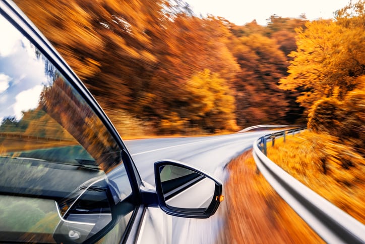 Driving in the fall Carolina Collision and Frame Service | Car driving on a windy highway with fall scenery of gold leaves on trees
